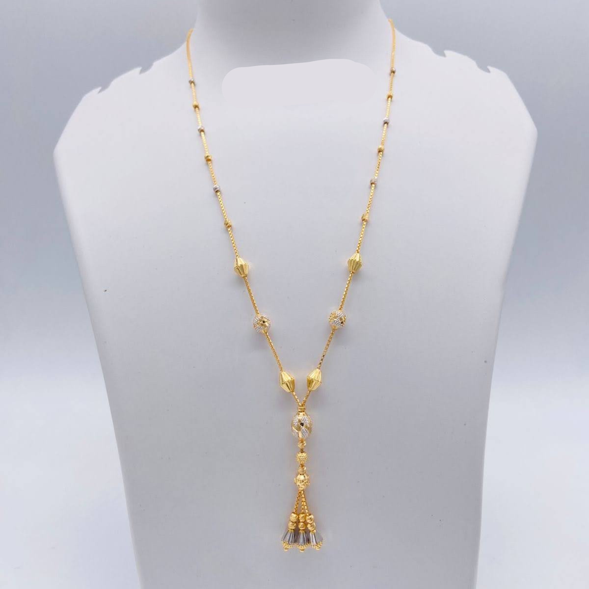 Gold necklace with tassel pendant on a mannequin bust, weight 7.770g, brand 'Sj221'.