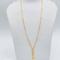 Gold necklace on a mannequin bust with dimensions displayed