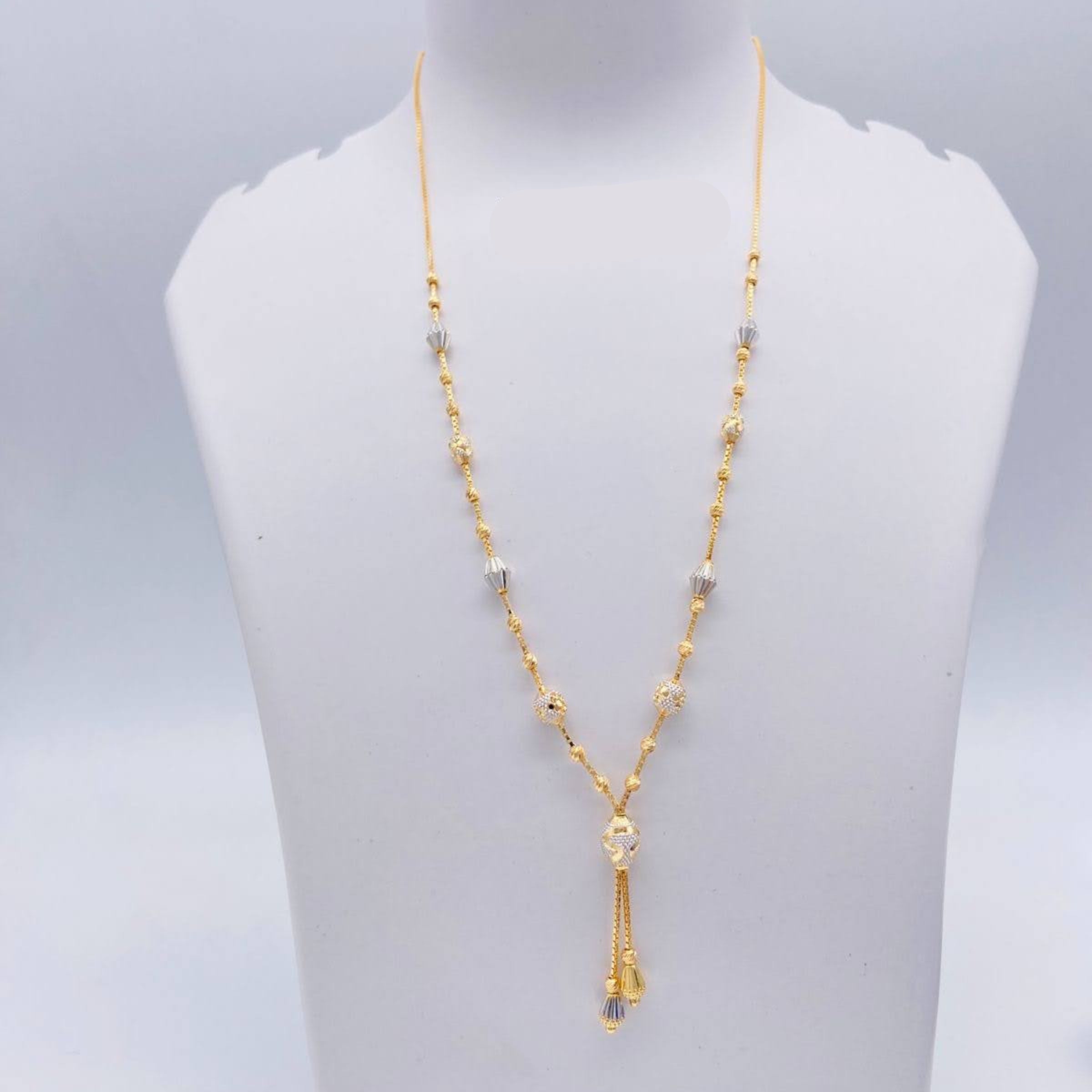 Gold necklace on a white mannequin bust with weight indication