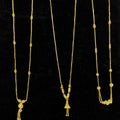 Three gold necklaces on a black display stand