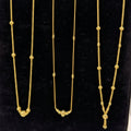 Three gold necklaces on a black stand