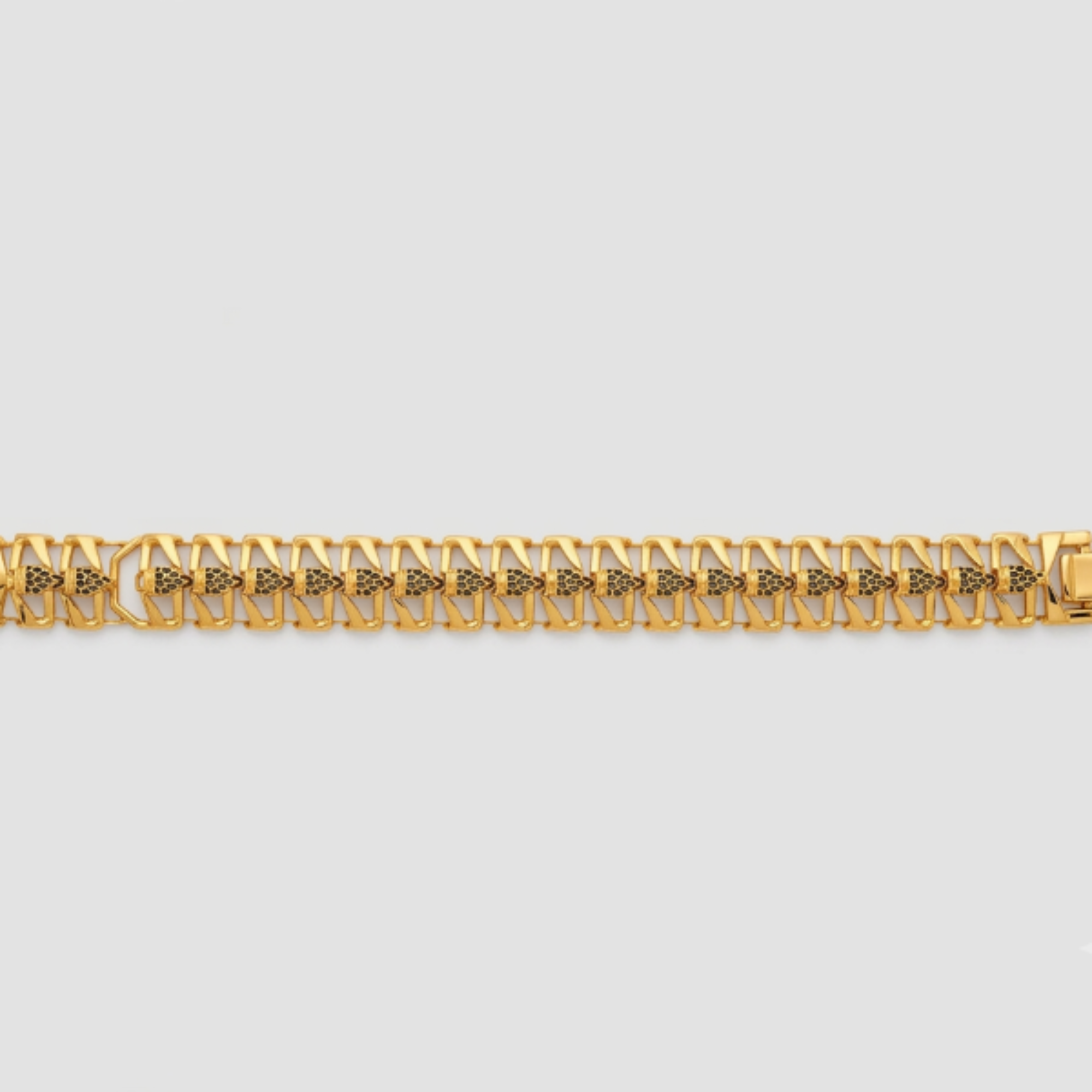 A gold-toned metal link bracelet with a repeating geometric pattern, displayed horizontally against a light gray background.