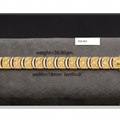 A gold-toned metal link bracelet with a textured geometric pattern and a clasp, displayed on a dark gray velvet surface. Black text overlays indicate the product's weight (36.