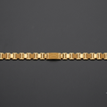 A gold-toned metal link bracelet with a textured center clasp, displayed horizontally on a dark gray background.