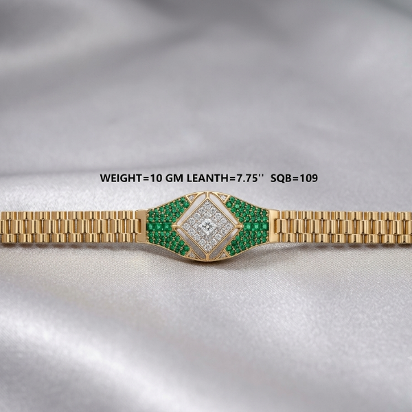 A gold-tone watch band with a decorative center section paved with green emerald-cut stones and a central diamond, displayed on a draped silver satin fabric. Text overlay reads 'WEIGHT=10 GM LEANTH=7.