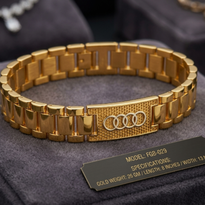A gold-tone metal bracelet with a textured center plate featuring the four-ring Audi logo, displayed on a dark gray velvet jewelry stand with a black specification plaque in front.