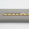 A gold bracelet with green emerald-cut stones and gold geometric detailing, displayed horizontally on a gray textured surface with a white label showing specifications.