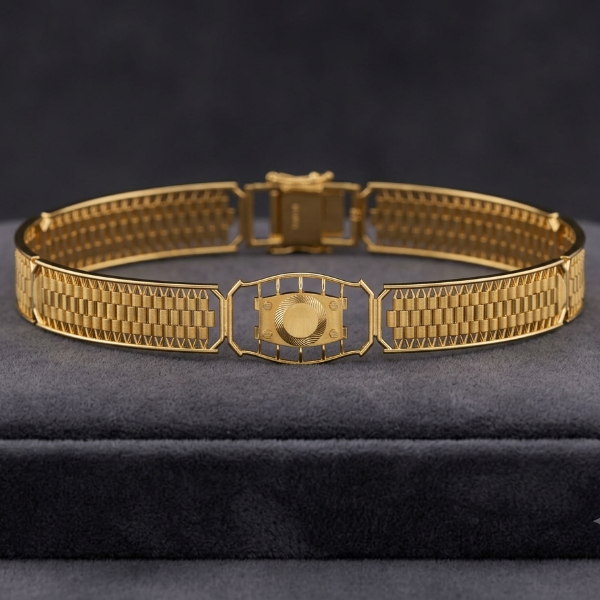 A gold-toned metal bracelet with a textured, woven mesh-like pattern and a central decorative clasp, displayed on a dark gray velvet jewelry box against a dark gray background.