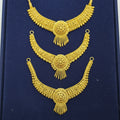 Three ornate gold-toned traditional necklace pieces displayed on a dark blue velvet background.