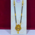 A traditional Indian gold and black bead necklace (manglik) with an ornate gold pendant, displayed on a white stand against a dark red background.