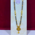 A traditional Indian gold and black beaded necklace (Murugai) with a detailed gold pendant, displayed on a white jewelry stand against a dark red background.