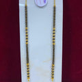 Two gold and black beaded hair strands on a white card with a red background