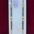 Two gold and black beaded necklaces on a white stand with a red background