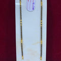Two gold necklaces on a white stand with a red background