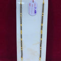 Two gold and black beaded necklaces on a white card with a red background