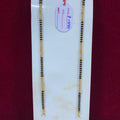 Two gold and black beaded necklaces on a white marble slab with a price tag.