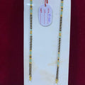Two gold necklaces on a white card with a red background