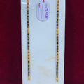 Two black and gold beaded bracelets on a white card with a price tag against a red background.