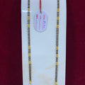 Two gold necklaces on a white card with a red background