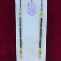 Two gold and black beaded necklaces on a white card with a red background