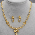Gold-tone jewelry set displayed on a gray velvet mannequin bust, including a necklace and matching earrings, with overlaid text reading 'gold wt = 13.5 gm'.