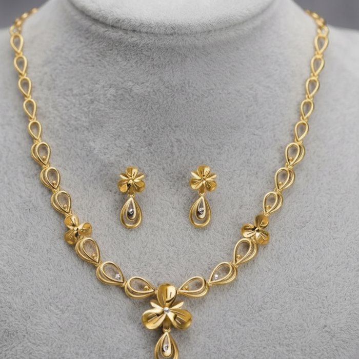 Gold-tone jewelry set displayed on a gray velvet mannequin bust, including a necklace and matching earrings, with overlaid text reading 'gold wt = 13.5 gm'.
