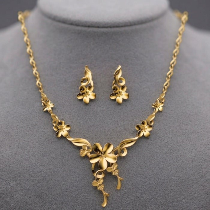 Gold floral necklace and matching stud earrings displayed on a gray jewelry bust against a dark gray background.