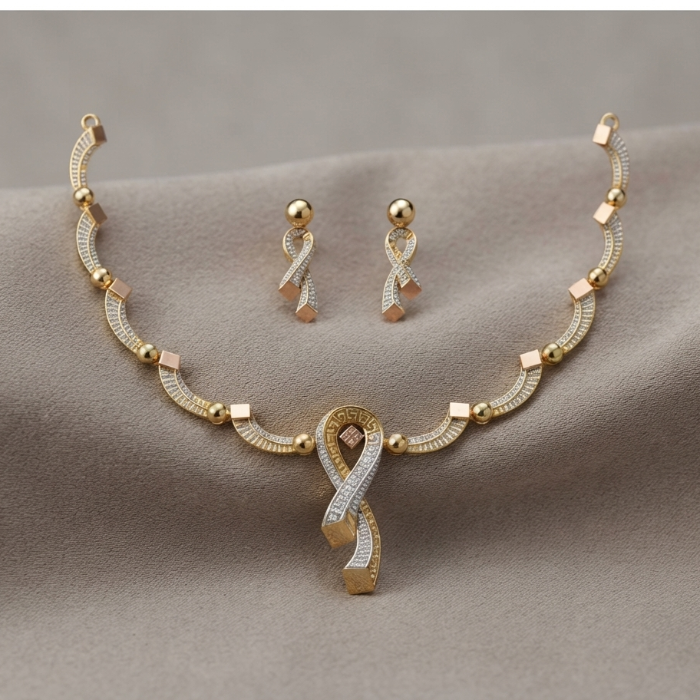 Gold-toned jewelry set featuring a necklace and matching earrings with ribbon-shaped pendants and small square accents, displayed on a soft beige fabric background.