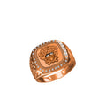 A rose gold signet ring featuring an embossed Medusa head on a square face, bordered by small clear stones, shown on a plain white background.