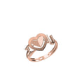A rose gold ring featuring a heart-shaped cutout design with a polished band, shown on a plain white background with a small model number and logo at the bottom.