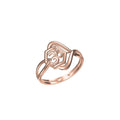A rose gold ring with a geometric, openwork design featuring a stylized heart and circular motif on a clean white background. A small code label 'SILR-8527' and a logo 'DC' are visible at the bottom.