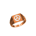 A rose gold signet ring with a white peace symbol inlay on a square face, shown on a plain white background with a product code label and 'DC' logo at the bottom.
