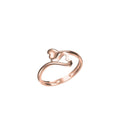 A rose gold ring with a stylized heart design on a plain white background, featuring a small code label in the bottom left corner and a logo at the bottom center.