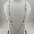 A gold necklace with small bead details and a teardrop pendant, displayed on a white jewelry bust with a digital scale underneath.