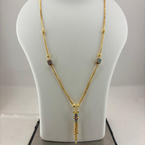 A gold necklace with a tassel pendant and small colorful stone accents, displayed on a white jewelry bust scale on top of a digital scale showing 9.92 grams.
