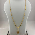 A gold chain necklace with a teardrop-shaped pendant displayed on a white jewelry bust, with a digital scale visible underneath.