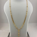 A gold necklace displayed on a white mannequin bust, with a digital scale visible underneath.