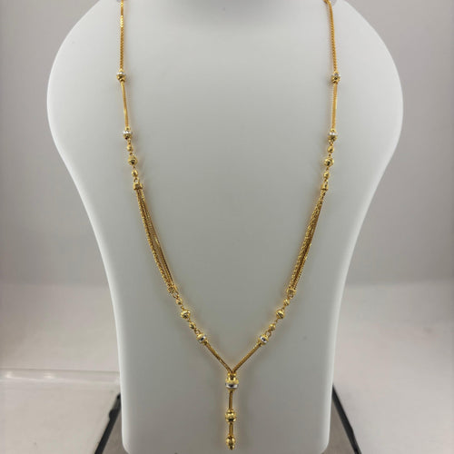 A gold necklace displayed on a white mannequin bust, with a digital scale visible underneath.
