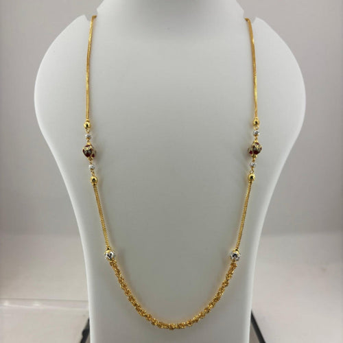 A gold chain necklace with small decorative beads displayed on a white jewelry bust, with a digital scale visible underneath.