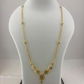 A gold necklace displayed on a white mannequin bust, with a digital scale visible underneath. The necklace features a delicate chain with small bead accents and a V-shaped pendant with floral clusters and a teardrop charm.