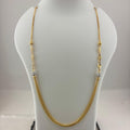 A gold chain necklace with small bead details and clear spacer beads, displayed on a white mannequin bust with a digital scale underneath.