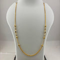 A gold chain necklace with small bead details draped on a white jewelry display bust, with a digital scale visible underneath.