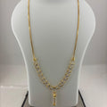 A gold necklace displayed on a white mannequin bust, with a digital scale visible underneath. The necklace features a delicate chain with a V-shaped arrangement of small gold links and a central pendant.