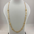 A gold multi-strand necklace displayed on a white mannequin bust, with a digital scale visible underneath. The necklace features multiple layers of chain with small gold bead and textured details.