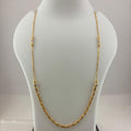 A gold chain necklace displayed on a white mannequin bust, with a digital scale visible underneath.
