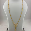 A gold necklace with a four-leaf clover pendant displayed on a white mannequin bust, with a digital scale visible underneath.