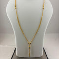 A gold-toned chain necklace with a decorative pendant is displayed on a white mannequin bust, with a digital scale visible underneath.
