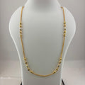 A gold chain necklace with small bead accents displayed on a white mannequin bust, with a digital scale visible underneath.