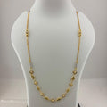 A gold chain necklace with small diamond-shaped and floral motifs displayed on a white mannequin bust, with a digital scale visible underneath.