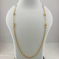 A gold chain necklace with small bead-like links and decorative spacer beads, displayed on a white jewelry bust. The bust is placed on top of a digital scale showing a weight of 8.